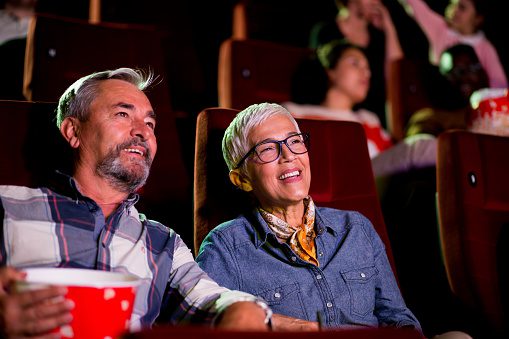 Portrait of a happy senior couple watching a show