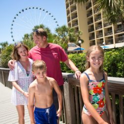 Family walking on Myrtle Beach Boardwalk outside Holiday Inn – "At the Pavilion"