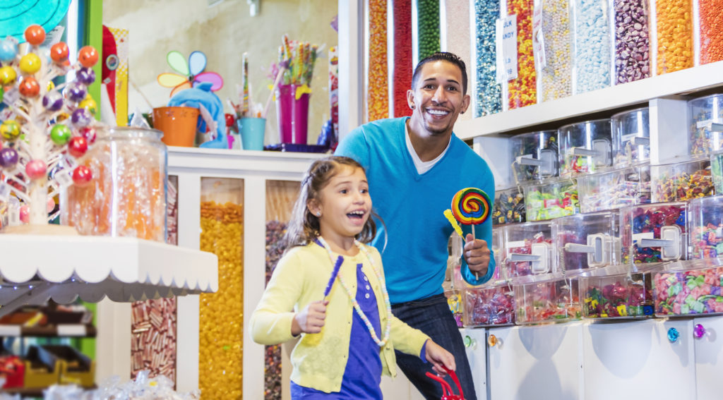 a father and daughter having fun at i love suger, one of the shops on the myrtle beach boardwalk